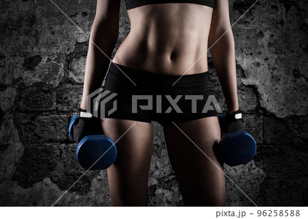 Athletic woman training biceps on grunge background Athletic woman training biceps on grunge background 96258588
