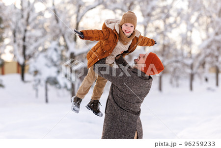 Little son having fun with dad while playing in winter park during New year and Christmas holidays 96259233