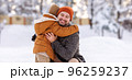 Happy family enjoying snowy weather outdoor, dad with little son hugging during walk in winter park 96259237