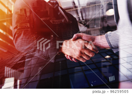Handshaking business person in office. concept of teamwork and partnership. double exposure Handshaking business person in office. concept of teamwork and partnership. double exposure 96259505