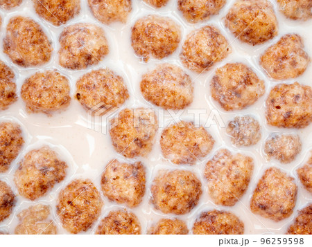 Top view of corn flakes floating in milk close up. Top view of corn flakes floating in milk close up. 96259598