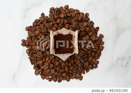 Drip pack stands on roasted coffee beans. The concept of delicious and convenient coffee preparation. Top view. 96260190