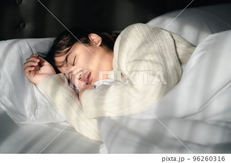 Young woman sleeping on white bed. 96260316