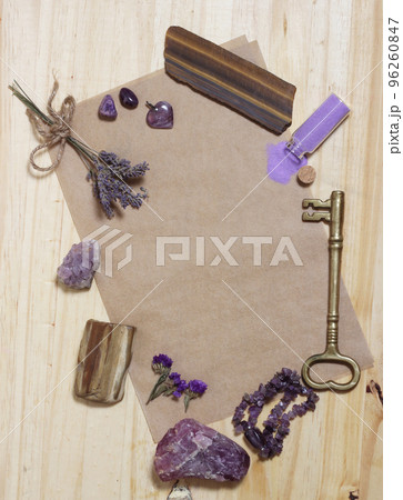 Amethyst Stones With Petrified Wood on Old Paper With Dried Flowers and Key. Purple Theme Background Amethyst Stones With Petrified Wood on Old Paper With Dried Flowers and Key. Purple Theme Background 96260847