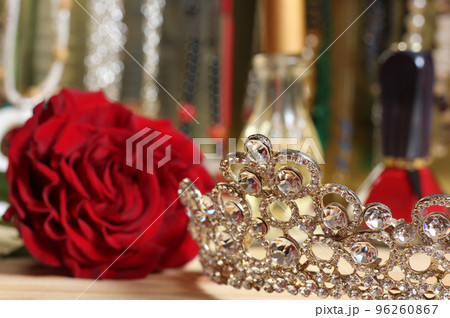 Rose and Tiara with Perfume and Jewelry in Background 96260867