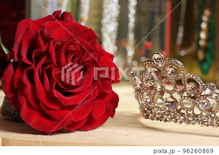 Rose and Tiara with Perfume and Jewelry in Background 96260869