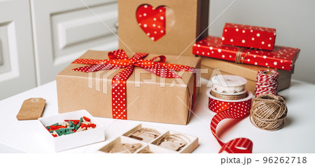 Christmas Gift Wrap Boxes and Supplies. Red brown Xmas Gift box, kraft paper shopping bag and ribbons for wrapping. Sustainable Eco-Friendly zero waste Christmas Gift Wrap. 96262718