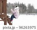 a child on a playground in winter climbs a rope 96263975