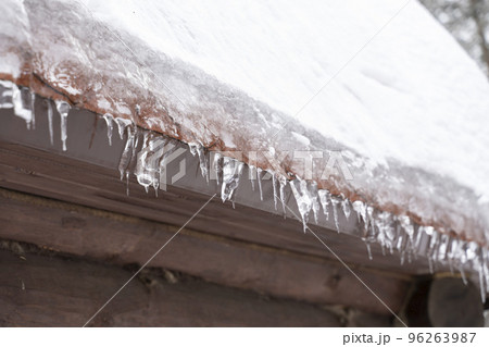 Close-up of melting snow icicles on roof. Close-up of melting snow icicles on roof. 96263987