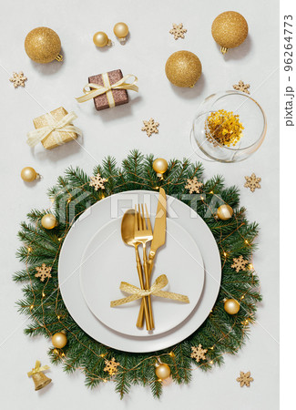 Golden Christmas table setting with a gifts and festive decorations on a gray background. Vertical orientation. View from above. 96264773