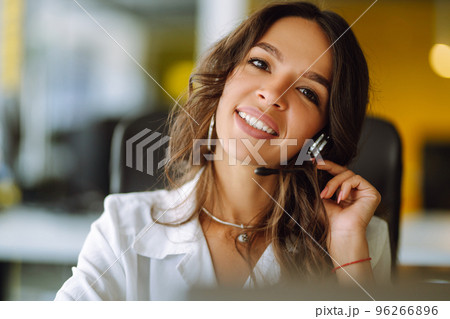 Young operator woman agent with headsets working in a call centre. Call center service. 96266896