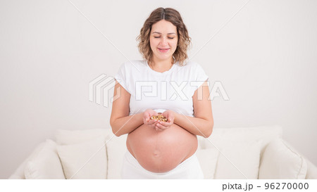Pregnant woman holding a handful of walnuts. Pregnant woman holding a handful of walnuts. 96270000