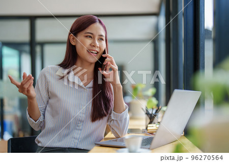 Asian businesswoman using the phone to contact a business partner. 96270564