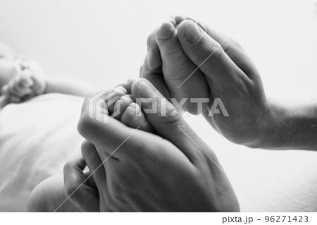 Legs, toes, feet and heels of a newborn. With the hands of parents, father, mother gently holds the child's legs. Macro photography, close-up. Black and white photo. High quality photo Legs, toes, feet and heels of a newborn. With the hands of parents, father, mother gently holds the child's legs. Macro photography, close-up. Black and white photo. High quality photo 96271423
