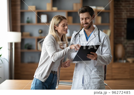 Handsome Male Doctor In Uniform Discussing Treatment With Female Patient At Clinic Handsome Male Doctor In Uniform Discussing Treatment With Female Patient At Clinic 96272485