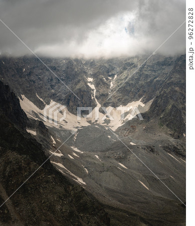 rocky cliff with snow, fog or thick low clouds cover the tops of the mountains, autumn 96272828
