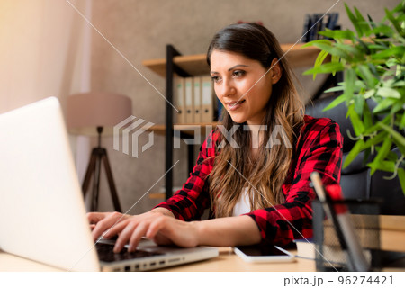 Girl teleworker works at home with a laptop Girl teleworker works at home with a laptop 96274421