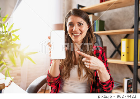 Girl does a video call with her family, due to covid19 coronavirus. White space on smartphone for your text 96274422