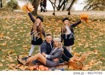 A big family on a picnic in the fall in a nature park. Happy people in the autumn park 96274760