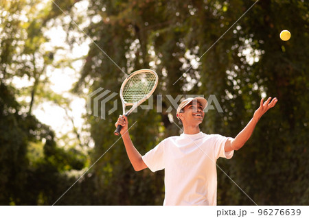 Young man in sportswear with a racket at the tennis court 96276639