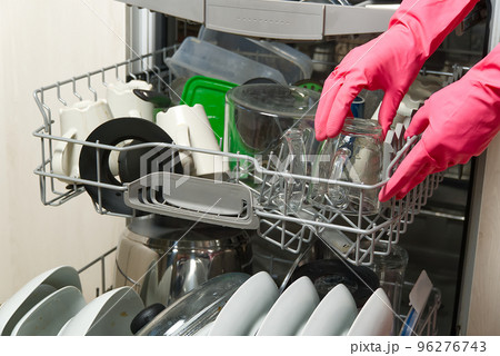Dirty dish in open integrated dishwasher. Open dishwasher with dirty dishes inside before washing. full loaded dishwasher ready for washing. Dirty dish in open integrated dishwasher. Open dishwasher with dirty dishes inside before washing. full loaded dishwasher ready for washing. 96276743