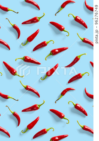 Creative background made of red chili or chilli on blue backdrop. Minimal food backgroud. Red hot chilli peppers background. 96276749