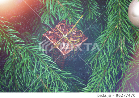 Christmas gift on the background of the Christmas tree close-up Christmas gift on the background of the Christmas tree close-up 96277470