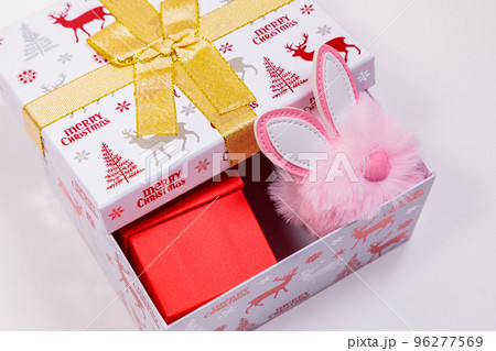 Christmas banner, holiday box with toys on a white background. Bunny ears out of the box. Christmas banner, holiday box with toys on a white background. Bunny ears out of the box. 96277569