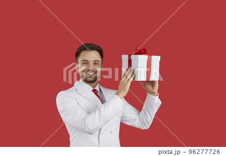Smiling man in suit holding gift box 96277726