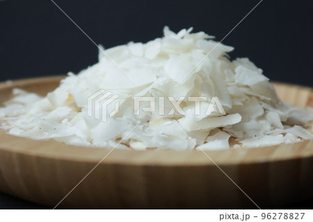 slice of fresh coconut flakes in a bowl on a table slice of fresh coconut flakes in a bowl on a table 96278827