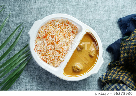 curry chicken and rice in a take away plastic packet on table  96278930