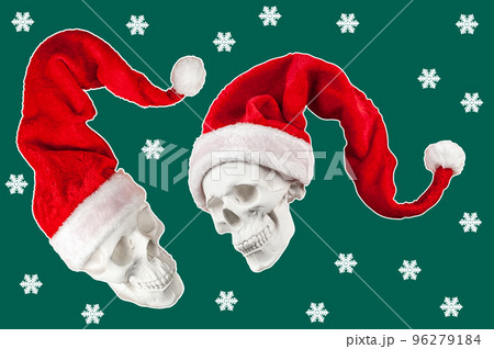 Two white spooky skull in bright red Santa Claus hat on green backdrop with snowflakes. Funky xmas decor. Crazy concept of holidays, cool party, 2023 New Year and Merry Christmas. Winter holiday mood. 96279184