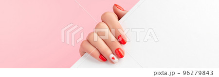 Manicured womans hand holding white paper. Fashionable valentines day nail design Manicured womans hand holding white paper. Fashionable valentines day nail design 96279843