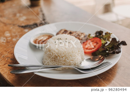 Baked chicken with white rice served on the table. 96280494