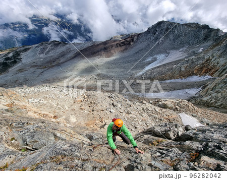 Via Ferrata mountain hike climber man climbing on steep rock in Whistler, BC, Canada travel destination. Summer adventure Via Ferrata mountain hike climber man climbing on steep rock in Whistler, BC, Canada travel destination. Summer adventure 96282042