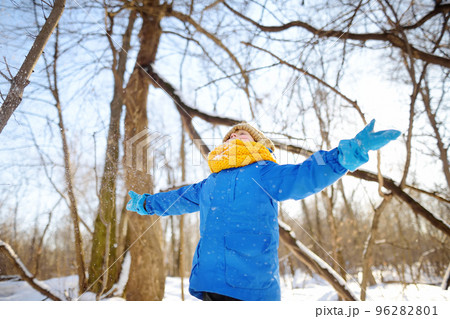 Little boy throwing fresh snow from his hands. Child enjoy walking in the park on snowy day. Baby having fun during snowfall. Outdoor winter activities for kids. Little boy throwing fresh snow from his hands. Child enjoy walking in the park on snowy day. Baby having fun during snowfall. Outdoor winter activities for kids. 96282801