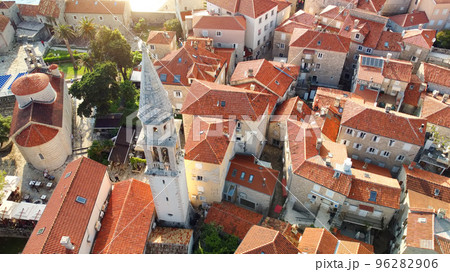 Panoramic sunset aerial drone view of ancient city of Budva, Montenegro. Old medieval town with red roofs. Kotor bay, coast of Adriatic sea. Budva is most popular resort town in Montenegro Panoramic sunset aerial drone view of ancient city of Budva, Montenegro. Old medieval town with red roofs. Kotor bay, coast of Adriatic sea. Budva is most popular resort town in Montenegro 96282906