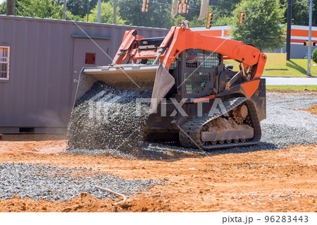 Excavator at construction site mini loader bobcat transports crushed stone to different construction places Excavator at construction site mini loader bobcat transports crushed stone to different construction places 96283443