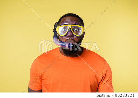 Man with snorkeling mask is scared to go underwater. yellow background 96283521
