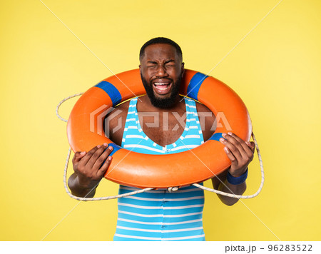 Man with lifebelt is scared to swim. yellow background 96283522