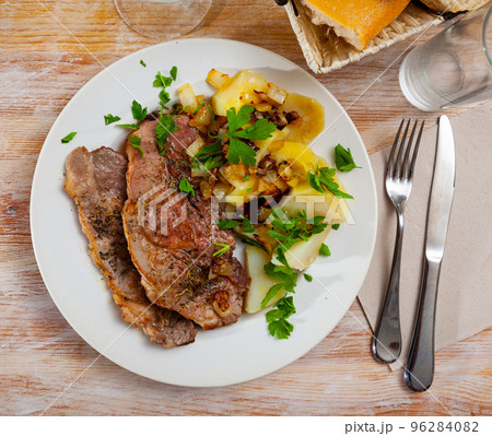 Pork chops with boiled potato, fried onion and parsley Pork chops with boiled potato, fried onion and parsley 96284082