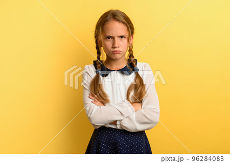 Young girl is unhappy and angry about something. yellow background 96284083