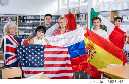 Group of young teenagers people holding international flags of many countries while studying 96284464