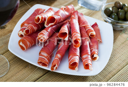 Traditional Spanish meal - rolls of iberian jamon served at plate 96284476