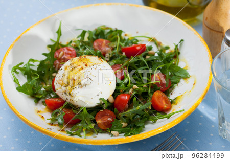 Salad with burrata cheese, pine nuts, cherry tomatoes and arugula Salad with burrata cheese, pine nuts, cherry tomatoes and arugula 96284499