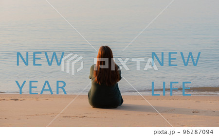 New year new life quote on the image of woman sitting on the sand beach. New year new life quote on the image of woman sitting on the sand beach. 96287094
