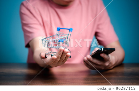 Shopping online with shopping cart, Man using Mobile Phone buy things on web page shop. Shopping online with shopping cart, Man using Mobile Phone buy things on web page shop. 96287115