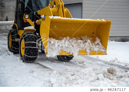 Tractor scoop with snow in the winter, Clearing snow after a storm. 96287117