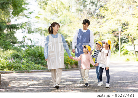 公園を散歩する保育士と園児 96287431