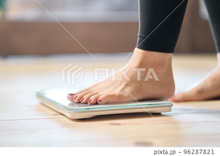 体重計に乗るアジア人女性の足元 96287821